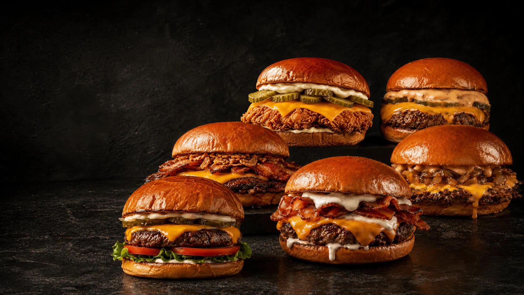 Las seis burgers de Los 9 del 9,90 reunidas sobre una mesa oscura